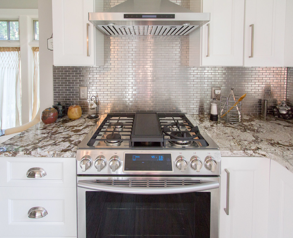 Example of a large classic l-shaped light wood floor and gray floor open concept kitchen design in Philadelphia with a drop-in sink, shaker cabinets, white cabinets, marble countertops, metallic backsplash, subway tile backsplash, stainless steel appliances, an island and multicolored countertops