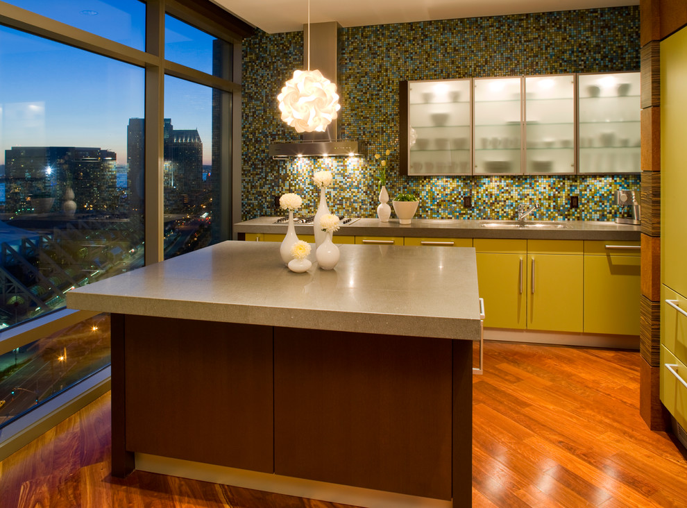 На фото: кухня в современном стиле с столешницей из бетона, плоскими фасадами, зелеными фасадами, разноцветным фартуком и фартуком из плитки мозаики