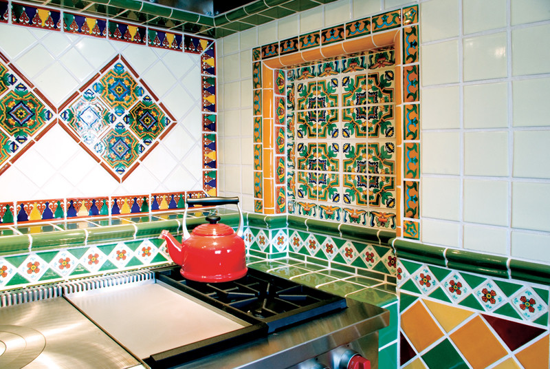 Immagine di una cucina mediterranea di medie dimensioni con top piastrellato, paraspruzzi multicolore, paraspruzzi con piastrelle in terracotta e elettrodomestici in acciaio inossidabile