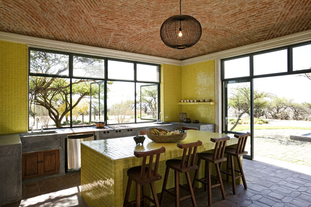 Пример оригинального дизайна: кухня в средиземноморском стиле с столешницей из плитки, желтым фартуком и желтой столешницей