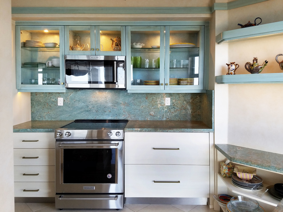 Inredning av ett modernt mellanstort turkos turkost kök, med en undermonterad diskho, luckor med glaspanel, turkosa skåp, granitbänkskiva, rostfria vitvaror, marmorgolv, en köksö och beiget golv