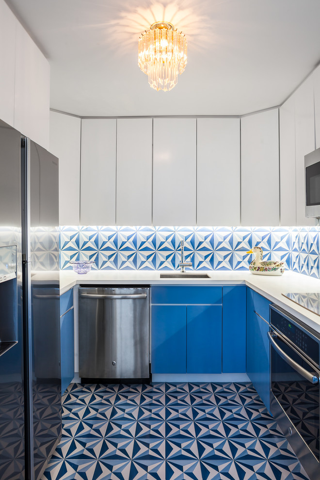 This is an example of a beach style u-shaped kitchen in Miami with a submerged sink, flat-panel cabinets, blue cabinets, multi-coloured splashback, stainless steel appliances and no island.