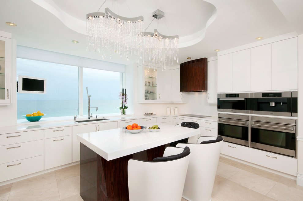 Inspiration for a large contemporary u-shaped marble floor enclosed kitchen remodel in Miami with flat-panel cabinets, white cabinets, an undermount sink, quartz countertops, stainless steel appliances, an island, white backsplash and white countertops