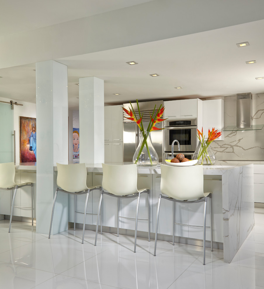 Exempel på ett mellanstort modernt kök, med en undermonterad diskho, släta luckor, vita skåp, marmorbänkskiva, vitt stänkskydd, glaspanel som stänkskydd, rostfria vitvaror, marmorgolv, en köksö och vitt golv