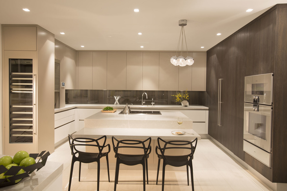 Moderne Wohnküche in U-Form mit Küchengeräten aus Edelstahl und Kücheninsel in Miami