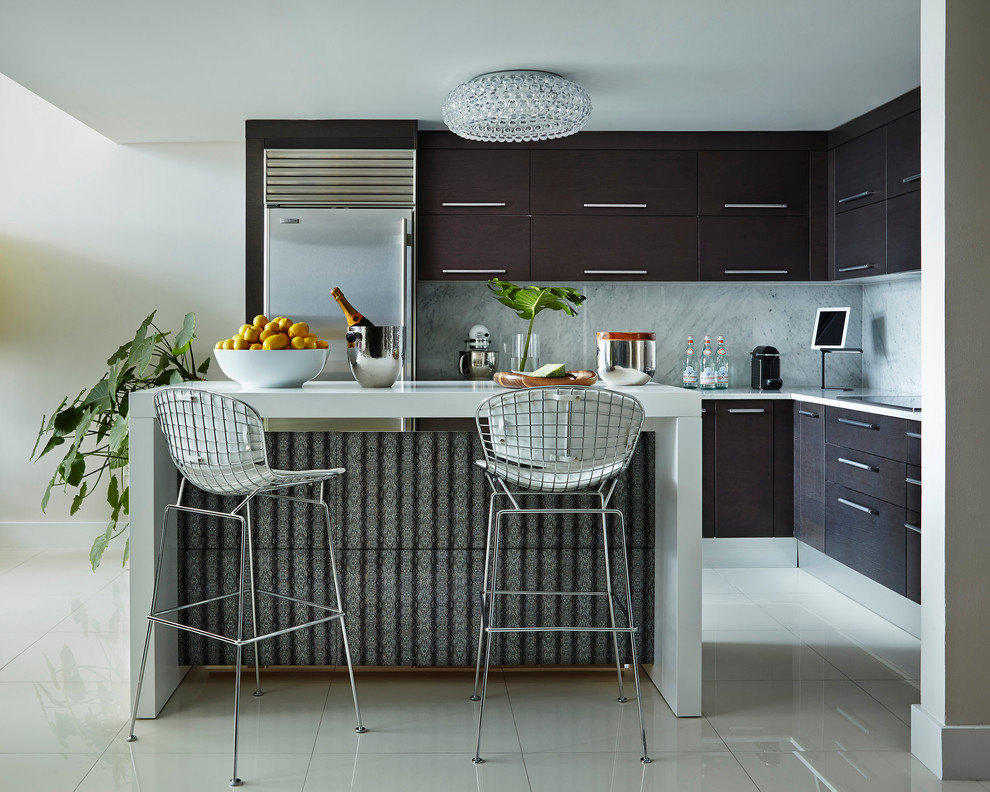 Moderne Küche mit flächenbündigen Schrankfronten, dunklen Holzschränken, Küchengeräten aus Edelstahl und Kücheninsel in Miami