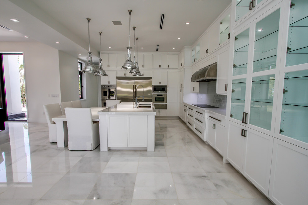 Idéer för ett stort modernt l-kök, med en undermonterad diskho, skåp i shakerstil, vita skåp, bänkskiva i kvarts, grått stänkskydd, stänkskydd i glaskakel, rostfria vitvaror, marmorgolv, en köksö och vitt golv