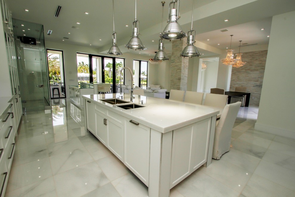 Foto di una grande cucina minimalista con lavello sottopiano, ante in stile shaker, ante bianche, top in quarzo composito, paraspruzzi grigio, paraspruzzi con piastrelle di vetro, elettrodomestici in acciaio inossidabile, pavimento in marmo e pavimento bianco