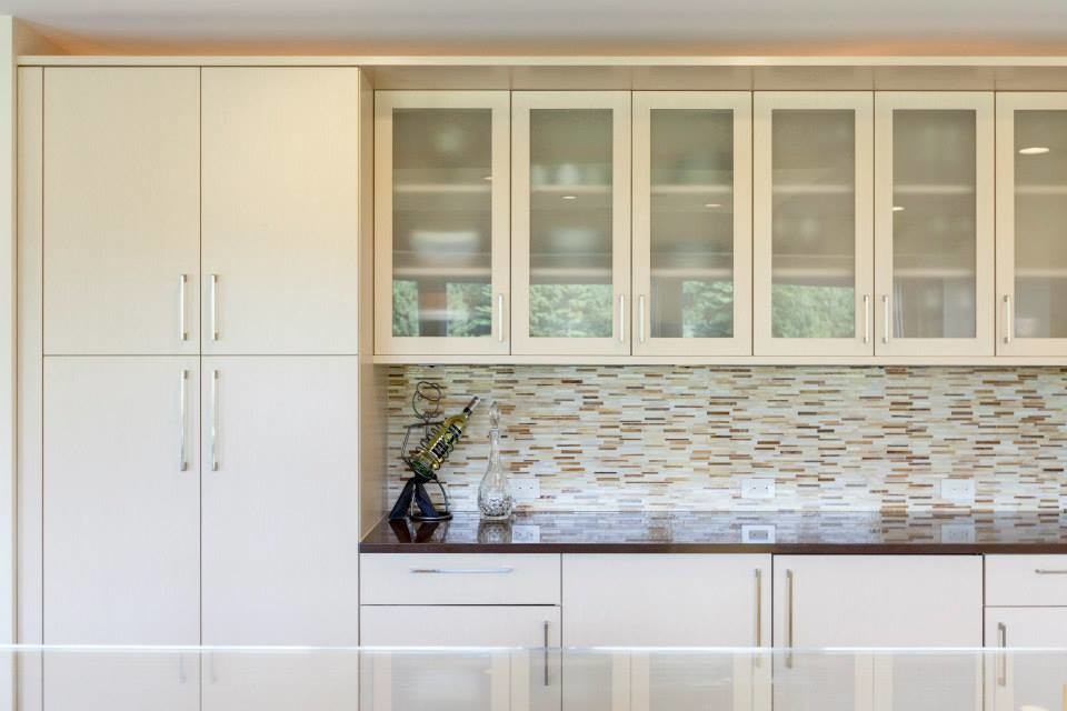 Immagine di una cucina moderna con ante di vetro, ante in legno chiaro, top in quarzo composito, paraspruzzi multicolore e paraspruzzi con piastrelle di vetro