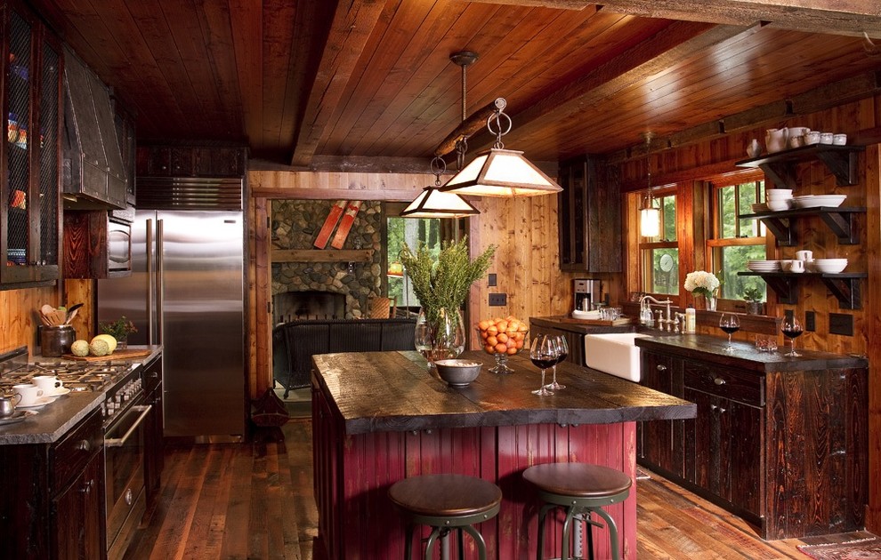 Mountain style enclosed kitchen photo in Minneapolis with stainless steel appliances, a farmhouse sink, dark wood cabinets and wood countertops