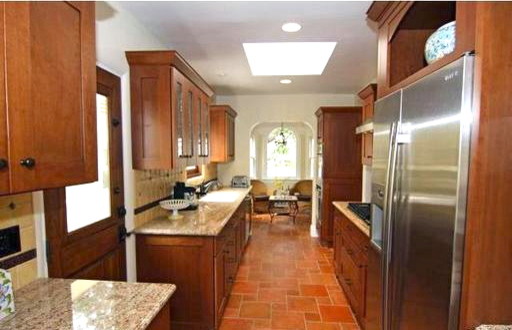 This is an example of a classic galley enclosed kitchen in Phoenix with a submerged sink, shaker cabinets, medium wood cabinets, granite worktops, ceramic splashback and stainless steel appliances.