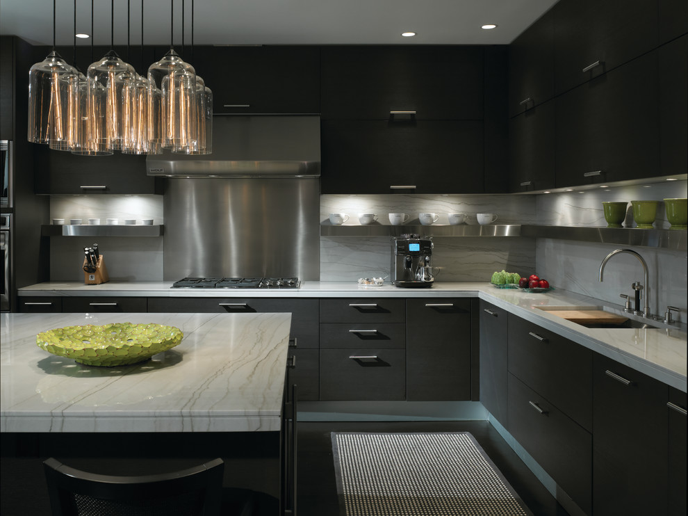 Inspiration for a contemporary kitchen in Chicago with a submerged sink, flat-panel cabinets, black cabinets, white splashback, stone slab splashback, stainless steel appliances and black floors.