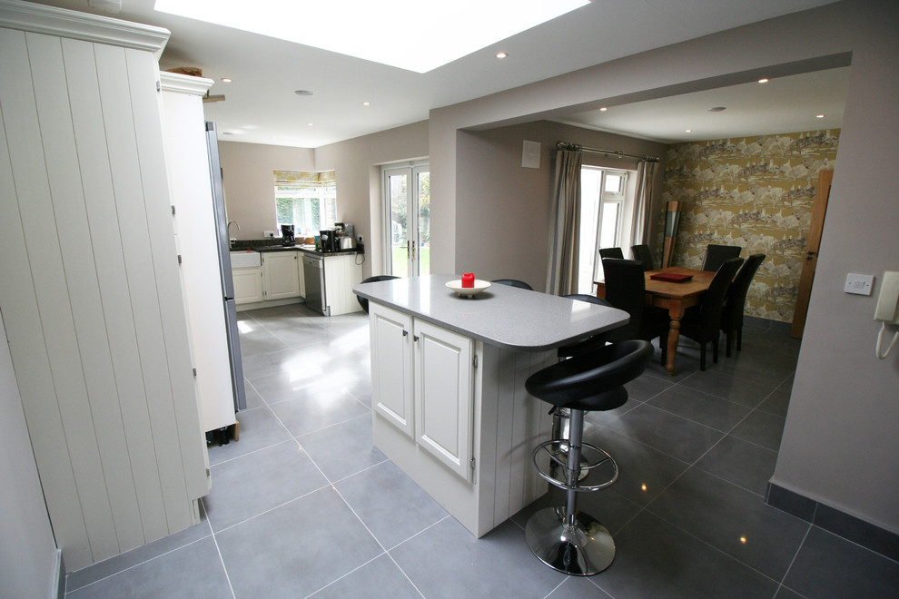 Foto di una cucina moderna di medie dimensioni con lavello a vasca singola, ante beige, top in quarzite, paraspruzzi nero e pavimento in gres porcellanato