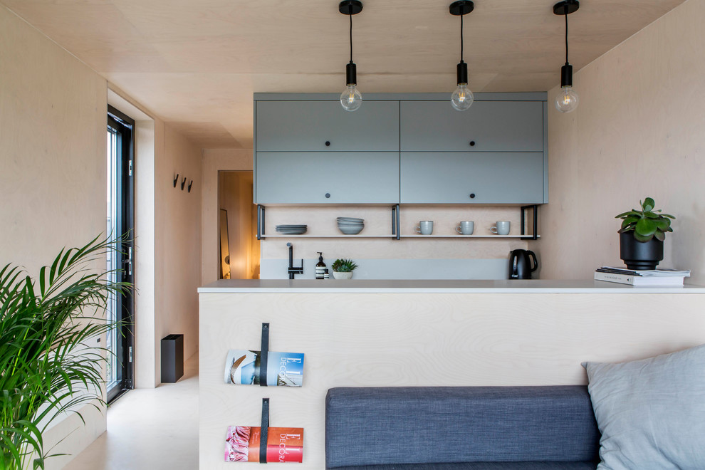 This is an example of a small scandinavian galley open plan kitchen in Oxfordshire with beige floors and grey worktops.