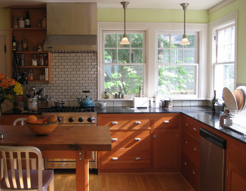Arts and crafts enclosed kitchen photo in Seattle with stainless steel appliances, granite countertops, medium tone wood cabinets, white backsplash and subway tile backsplash