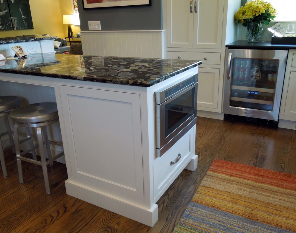 Elegant u-shaped eat-in kitchen photo in Boston with an undermount sink, beaded inset cabinets, white cabinets, granite countertops, multicolored backsplash and stainless steel appliances