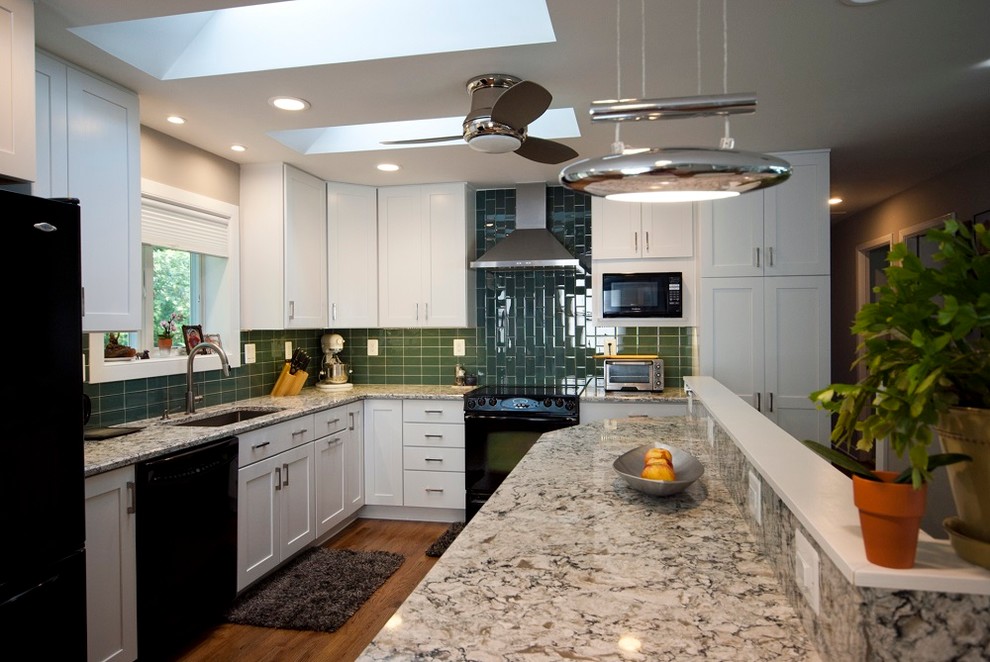 Inspiration for a mid-sized modern l-shaped medium tone wood floor eat-in kitchen remodel in Baltimore with an undermount sink, shaker cabinets, white cabinets, quartz countertops, green backsplash, glass tile backsplash, black appliances and a peninsula