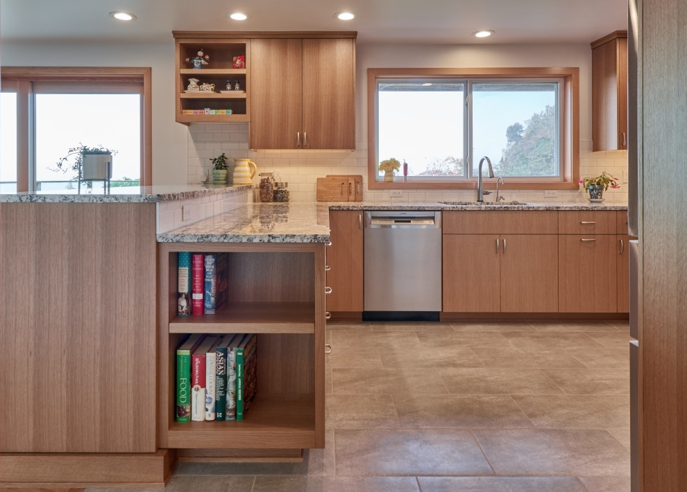 Retro inredning av ett mellanstort flerfärgad flerfärgat kök, med en dubbel diskho, släta luckor, skåp i ljust trä, granitbänkskiva, vitt stänkskydd, stänkskydd i keramik, rostfria vitvaror, klinkergolv i porslin, en halv köksö och grått golv
