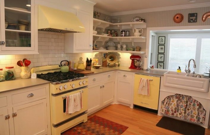 Mid-sized 1960s u-shaped light wood floor open concept kitchen photo in New Orleans with a farmhouse sink, beaded inset cabinets, white cabinets, quartz countertops, white backsplash, ceramic backsplash, colored appliances and a peninsula