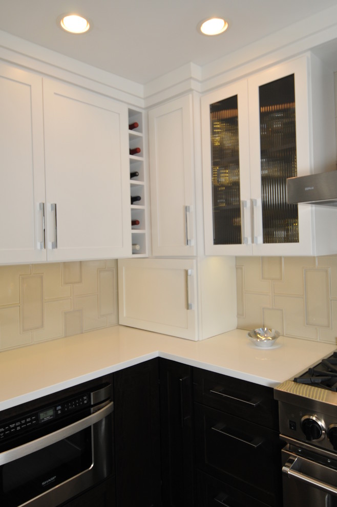 Inredning av ett modernt mellanstort kök, med en dubbel diskho, skåp i shakerstil, vita skåp, bänkskiva i kvarts, beige stänkskydd, stänkskydd i mosaik, rostfria vitvaror, mellanmörkt trägolv och en halv köksö