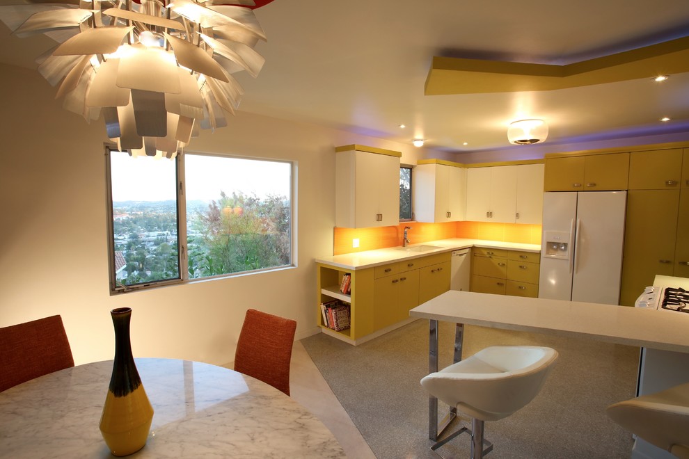 This is an example of a large retro kitchen/diner in Los Angeles with a double-bowl sink, flat-panel cabinets, green cabinets, engineered stone countertops, orange splashback, porcelain splashback, white appliances, travertine flooring and a breakfast bar.