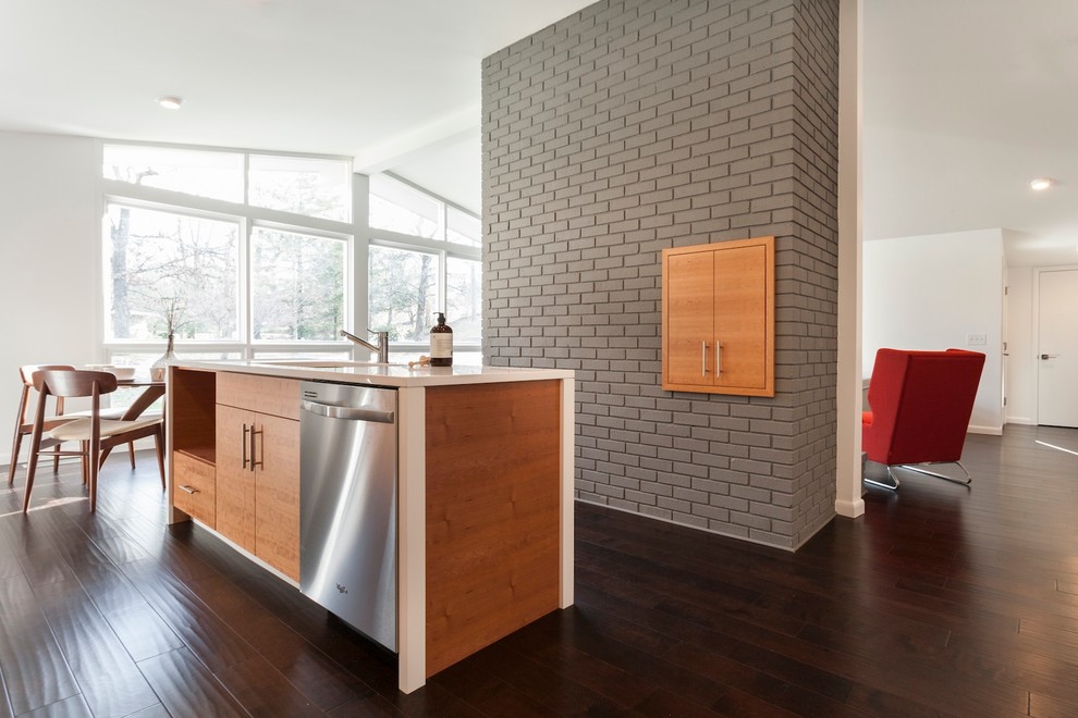 Example of a mid-sized 1960s galley dark wood floor eat-in kitchen design in Other with a double-bowl sink, flat-panel cabinets, light wood cabinets, solid surface countertops, white backsplash, stainless steel appliances and an island