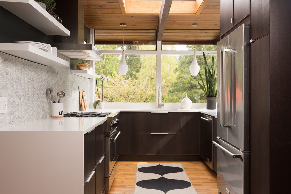 Modelo de cocina vintage, sin isla, con armarios con paneles lisos, puertas de armario de madera en tonos medios, salpicadero verde, salpicadero con mosaicos de azulejos, electrodomésticos de acero inoxidable y suelo de madera en tonos medios