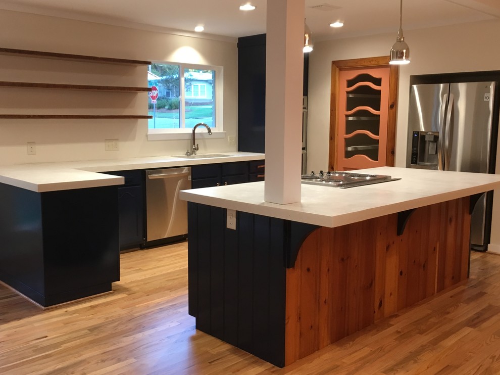 Example of a mid-sized transitional u-shaped light wood floor eat-in kitchen design in Miami with an undermount sink, shaker cabinets, blue cabinets, concrete countertops, white backsplash, stainless steel appliances and an island