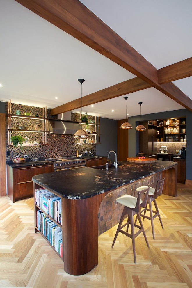 Foto de cocina comedor actual grande con armarios con paneles lisos, puertas de armario de madera en tonos medios, salpicadero marrón, salpicadero con mosaicos de azulejos, suelo de madera clara, una isla, fregadero sobremueble, encimera de granito y electrodomésticos de acero inoxidable