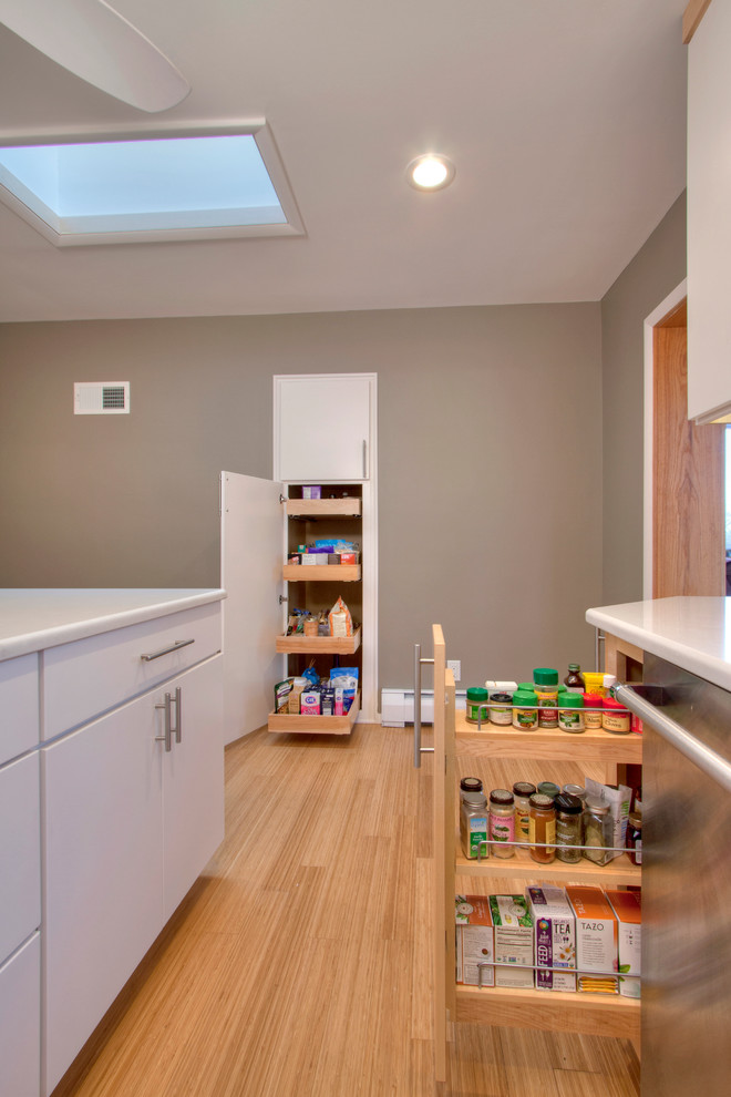 Inspiration for a mid-sized modern u-shaped bamboo floor enclosed kitchen remodel in St Louis with an undermount sink, flat-panel cabinets, white cabinets, quartzite countertops, gray backsplash, stone tile backsplash, stainless steel appliances and an island