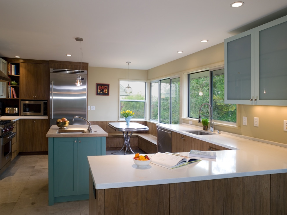 Cette photo montre une cuisine moderne avec un électroménager en acier inoxydable et un sol marron.