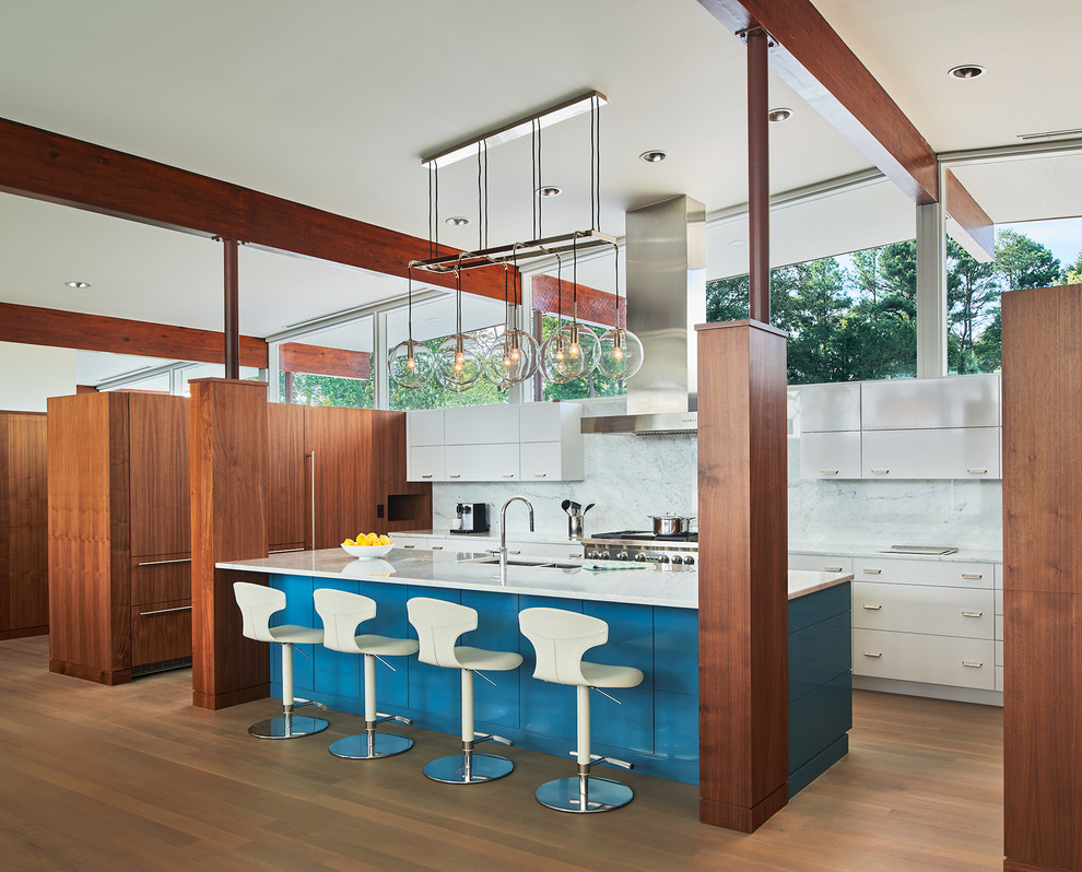 Design ideas for a medium sized retro u-shaped open plan kitchen in DC Metro with flat-panel cabinets, white cabinets, marble worktops, marble splashback, light hardwood flooring, an island, a double-bowl sink, white splashback, stainless steel appliances and brown floors.