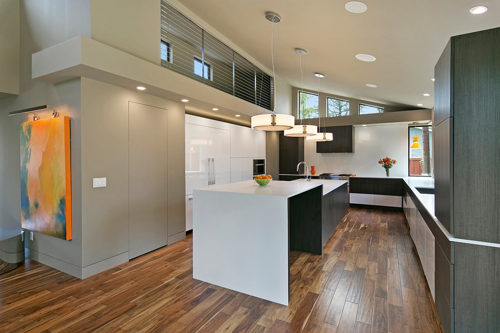Mid-Century Küche mit flächenbündigen Schrankfronten, weißen Schränken, Elektrogeräten mit Frontblende, dunklem Holzboden, Kücheninsel, braunem Boden und weißer Arbeitsplatte in San Francisco