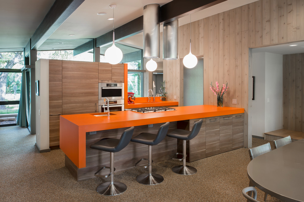 Example of a mid-century modern galley eat-in kitchen design in Austin with an undermount sink, flat-panel cabinets, light wood cabinets, laminate countertops, stainless steel appliances and orange countertops