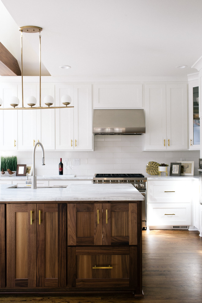 Inspiration for a large classic l-shaped kitchen/diner in Atlanta with a belfast sink, shaker cabinets, white cabinets, marble worktops, white splashback, ceramic splashback, stainless steel appliances, dark hardwood flooring and an island.