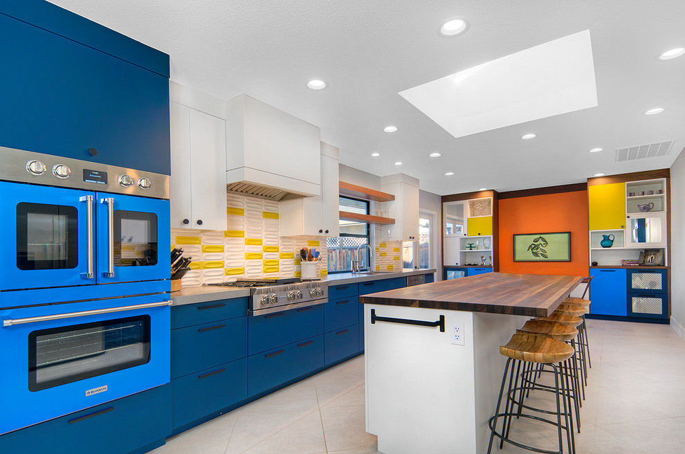 Foto de cocina comedor actual con fregadero bajoencimera, armarios con paneles lisos, puertas de armario azules, encimera de cuarzo compacto, salpicadero amarillo, salpicadero de azulejos de cerámica, electrodomésticos de colores, suelo de baldosas de cerámica, una isla, encimeras grises y suelo blanco