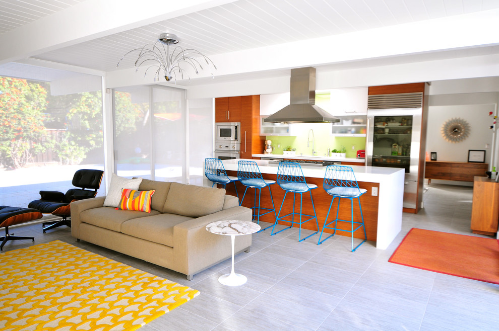 Mid-century modern galley open concept kitchen photo in San Francisco with flat-panel cabinets, medium tone wood cabinets, green backsplash and stainless steel appliances