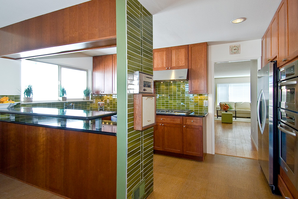 Mid-Century Wohnküche in U-Form mit Schrankfronten im Shaker-Stil, hellbraunen Holzschränken, Granit-Arbeitsplatte, Küchenrückwand in Grün, Küchengeräten aus Edelstahl, Korkboden und Rückwand aus Keramikfliesen in San Francisco