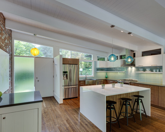 This is an example of a large midcentury l-shaped kitchen/diner in DC Metro with flat-panel cabinets, white cabinets, blue splashback, stainless steel appliances, medium hardwood flooring and an island.