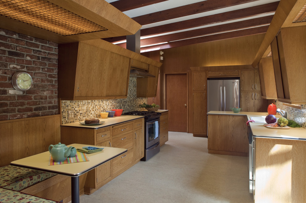 ポートランドにある中くらいなミッドセンチュリースタイルのおしゃれなキッチン (シルバーの調理設備、フラットパネル扉のキャビネット、中間色木目調キャビネット、ラミネートカウンター、マルチカラーのキッチンパネル、アイランドなし) の写真