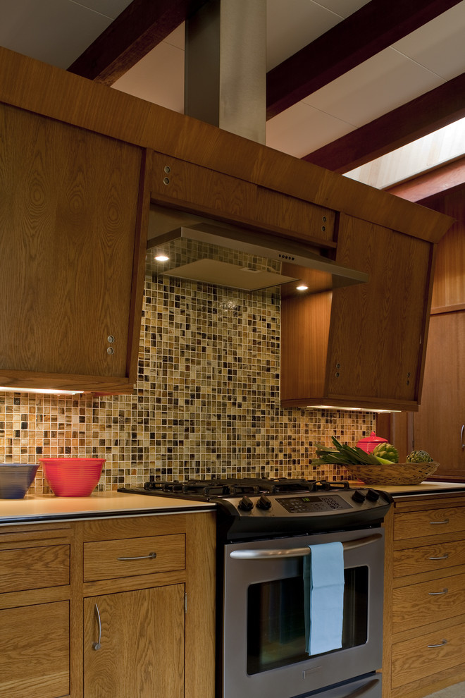 Example of a mid-sized mid-century modern u-shaped enclosed kitchen design in Portland with flat-panel cabinets, medium tone wood cabinets, multicolored backsplash, stainless steel appliances and no island
