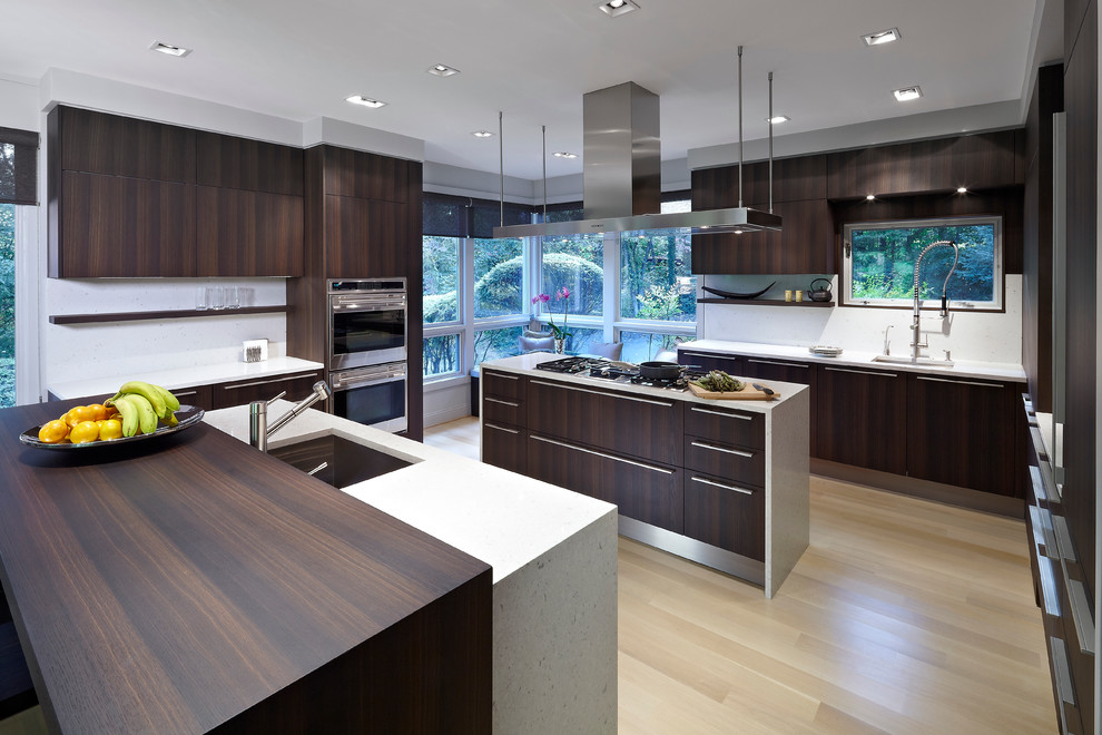 Eat-in kitchen - modern u-shaped eat-in kitchen idea in DC Metro with an integrated sink, flat-panel cabinets, dark wood cabinets, quartz countertops, white backsplash, stone slab backsplash and stainless steel appliances