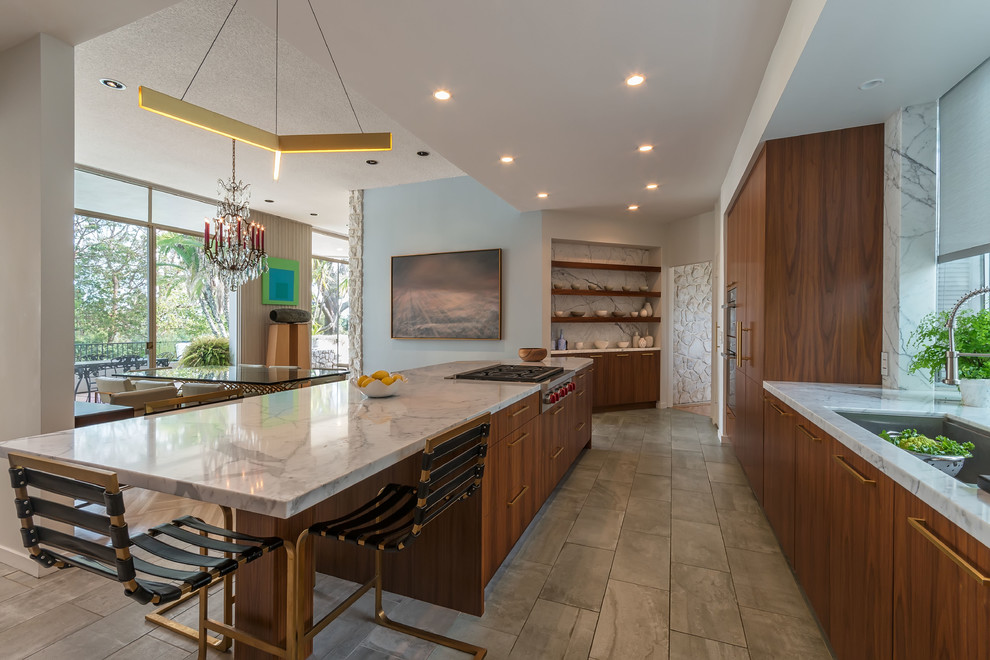 Foto på ett stort 50 tals kök och matrum, med en undermonterad diskho, släta luckor, marmorbänkskiva, integrerade vitvaror, klinkergolv i porslin, en köksö och skåp i mellenmörkt trä