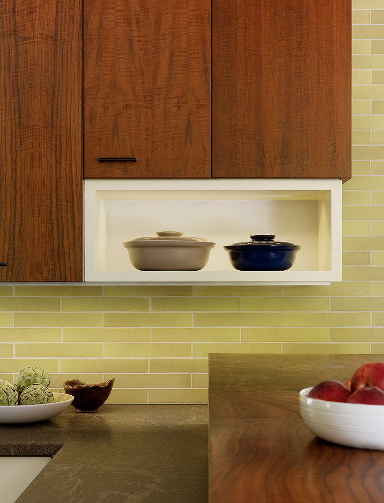 На фото: параллельная кухня-гостиная среднего размера в стиле ретро с фасадами цвета дерева среднего тона, зеленым фартуком и коричневой столешницей с