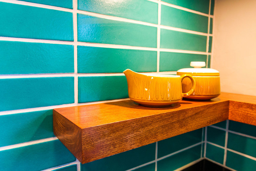 サクラメントにあるミッドセンチュリースタイルのおしゃれなアイランドキッチン (濃色木目調キャビネット、緑のキッチンパネル、セラミックタイルのキッチンパネル) の写真