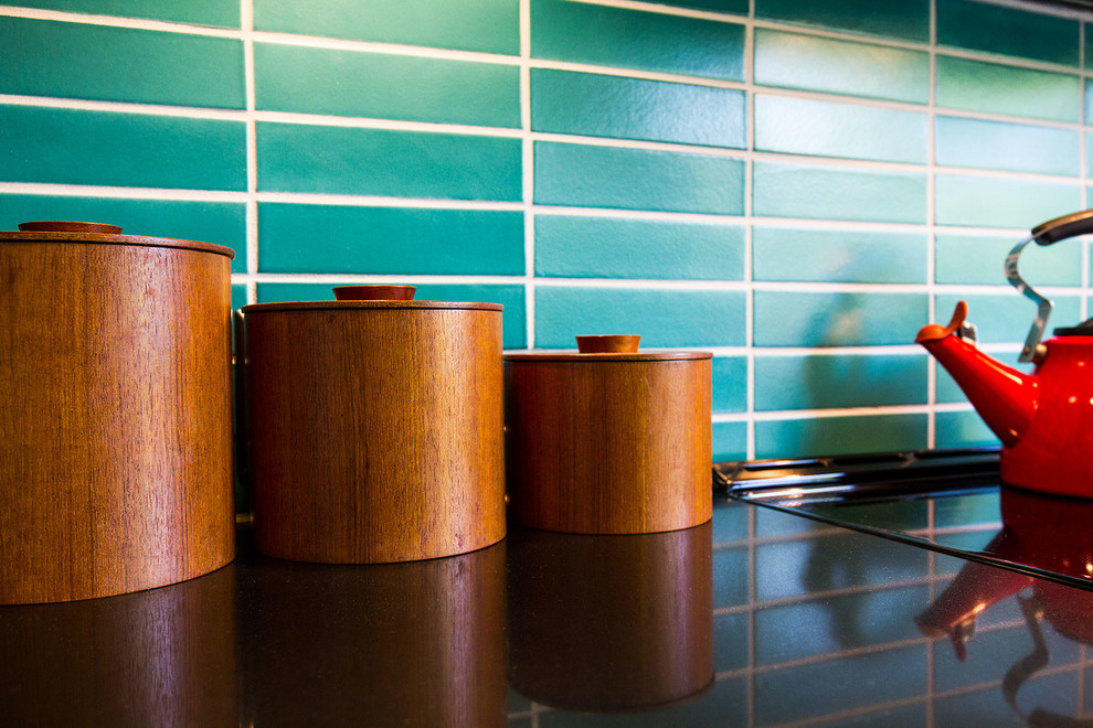 サクラメントにあるミッドセンチュリースタイルのおしゃれなアイランドキッチン (濃色木目調キャビネット、緑のキッチンパネル、セラミックタイルのキッチンパネル) の写真