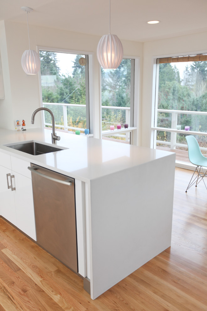 Eat-in kitchen - large 1950s u-shaped light wood floor eat-in kitchen idea in Seattle with a single-bowl sink, flat-panel cabinets, white cabinets, quartz countertops, stainless steel appliances, a peninsula, white backsplash and stone slab backsplash