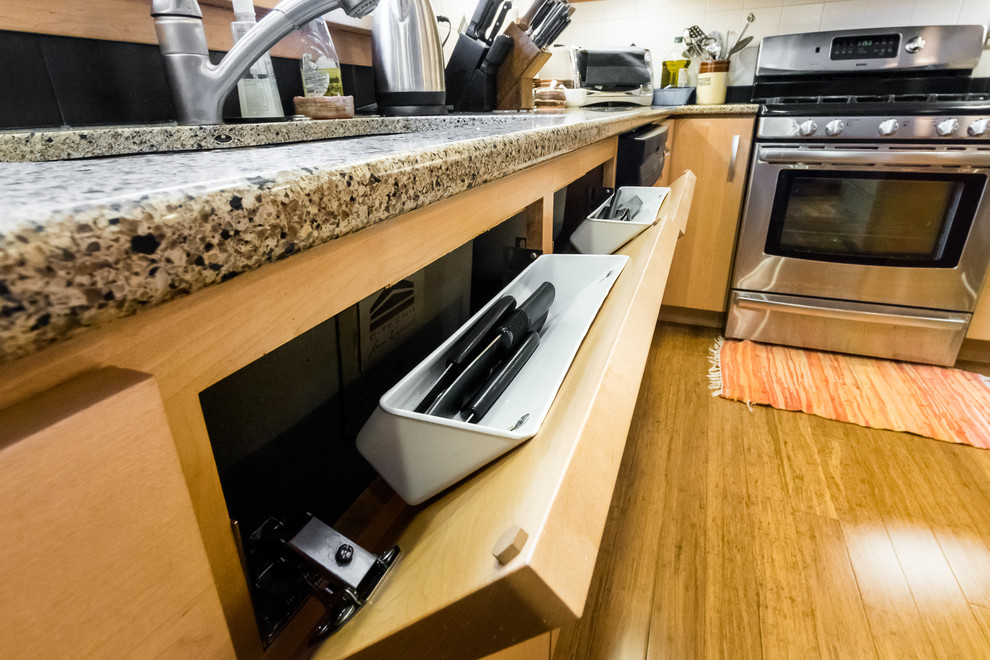 Immagine di una cucina moderna chiusa e di medie dimensioni con lavello sottopiano, ante lisce, ante in legno chiaro, top in granito, paraspruzzi bianco, paraspruzzi con piastrelle in ceramica, elettrodomestici in acciaio inossidabile e pavimento in bambù