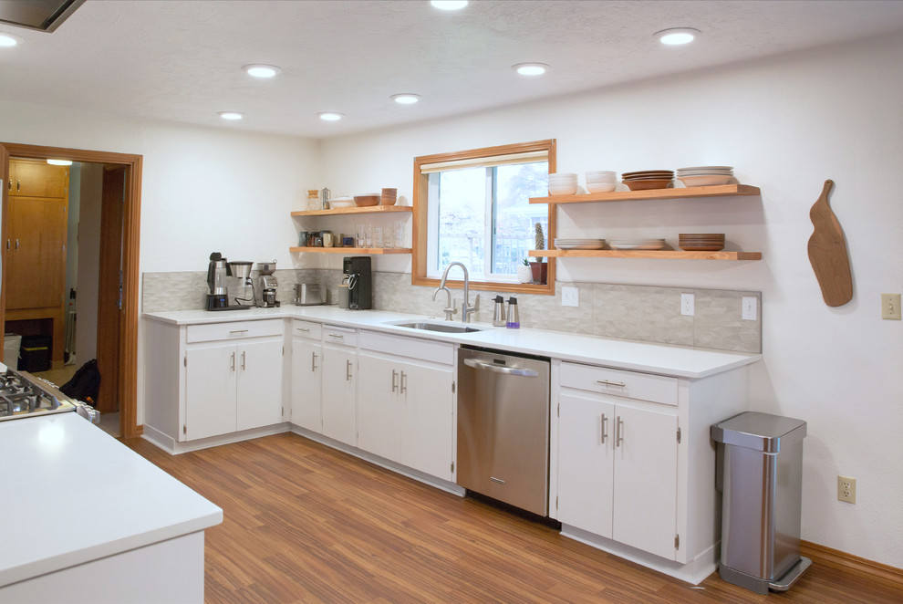 Inspiration for a large 1950s galley laminate floor and brown floor open concept kitchen remodel in Other with an undermount sink, flat-panel cabinets, white cabinets, quartz countertops, multicolored backsplash, porcelain backsplash, stainless steel appliances and a peninsula