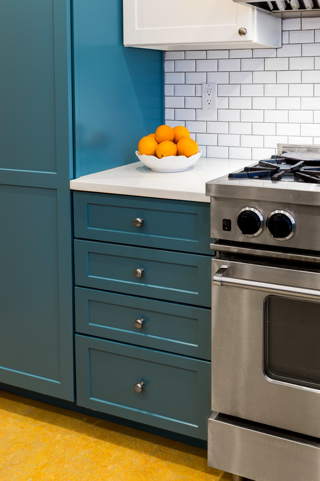 ポートランドにある高級な中くらいなミッドセンチュリースタイルのおしゃれなキッチン (アンダーカウンターシンク、シェーカースタイル扉のキャビネット、青いキャビネット、珪岩カウンター、白いキッチンパネル、サブウェイタイルのキッチンパネル、シルバーの調理設備、リノリウムの床、オレンジの床) の写真